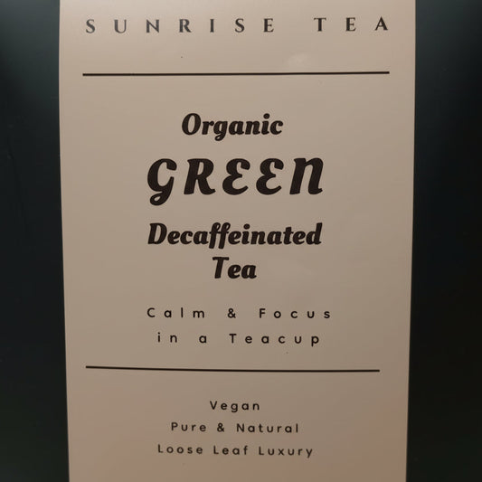 Tea package labeled 'Sunrise Tea' with text about organic green decaffeinated tea on a dark background.