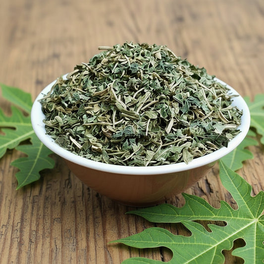 White bowl filled with dried green herbs on a wooden surface