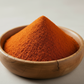 organic cayenne pepper powder in a wooden bowl