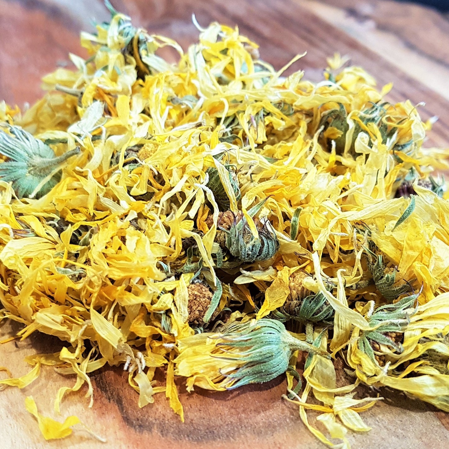 dried calendula flowers on a wooden cutting board