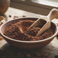 chocolatey brown cacao powder with a wooden scoop