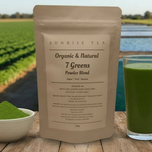Sunrise Tea Organic & Natural 7 Greens Powder Blend package with a glass of green juice and bowl of powder on a wooden surface with a scenic background.