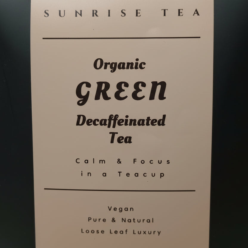 Tea package labeled 'Sunrise Tea' with text about organic green decaffeinated tea on a dark background.