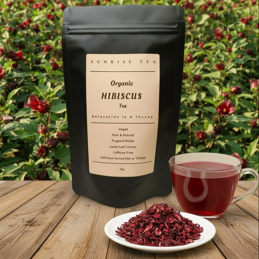 Hibiscus tea package with a cup of tea and dried hibiscus on a wooden table with a field in the background