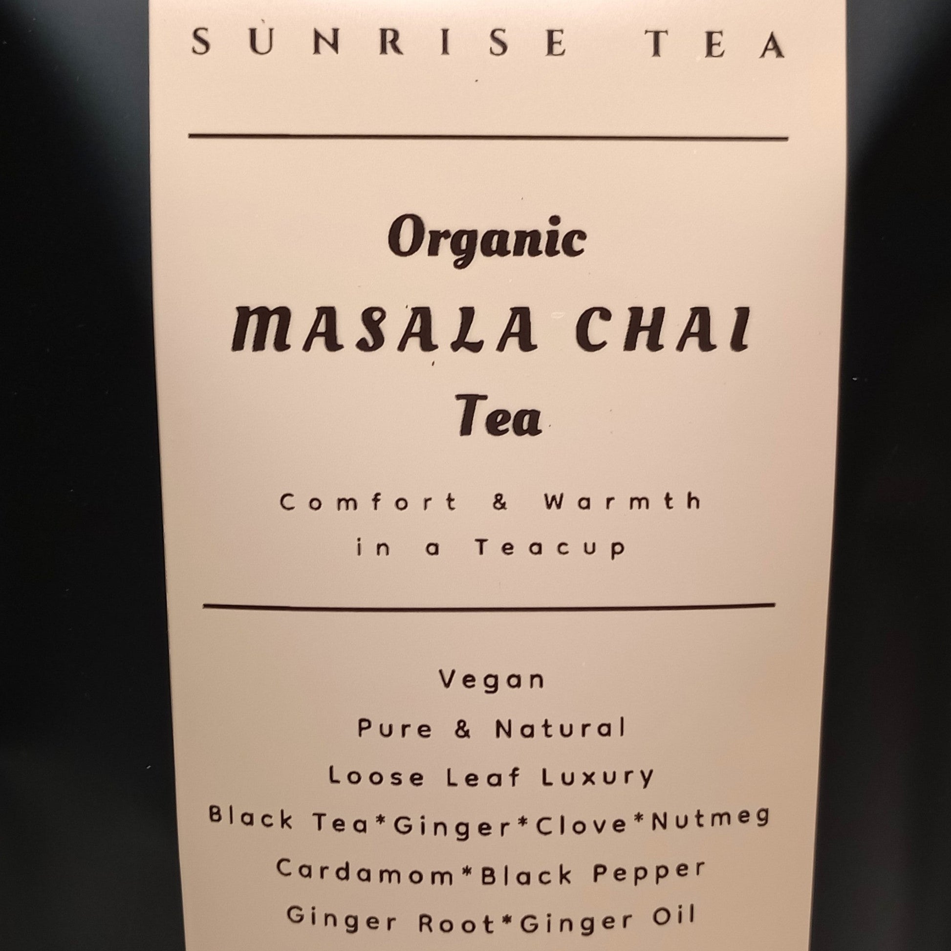 Black tea bag with 'Sunrise Tea' label on a white background