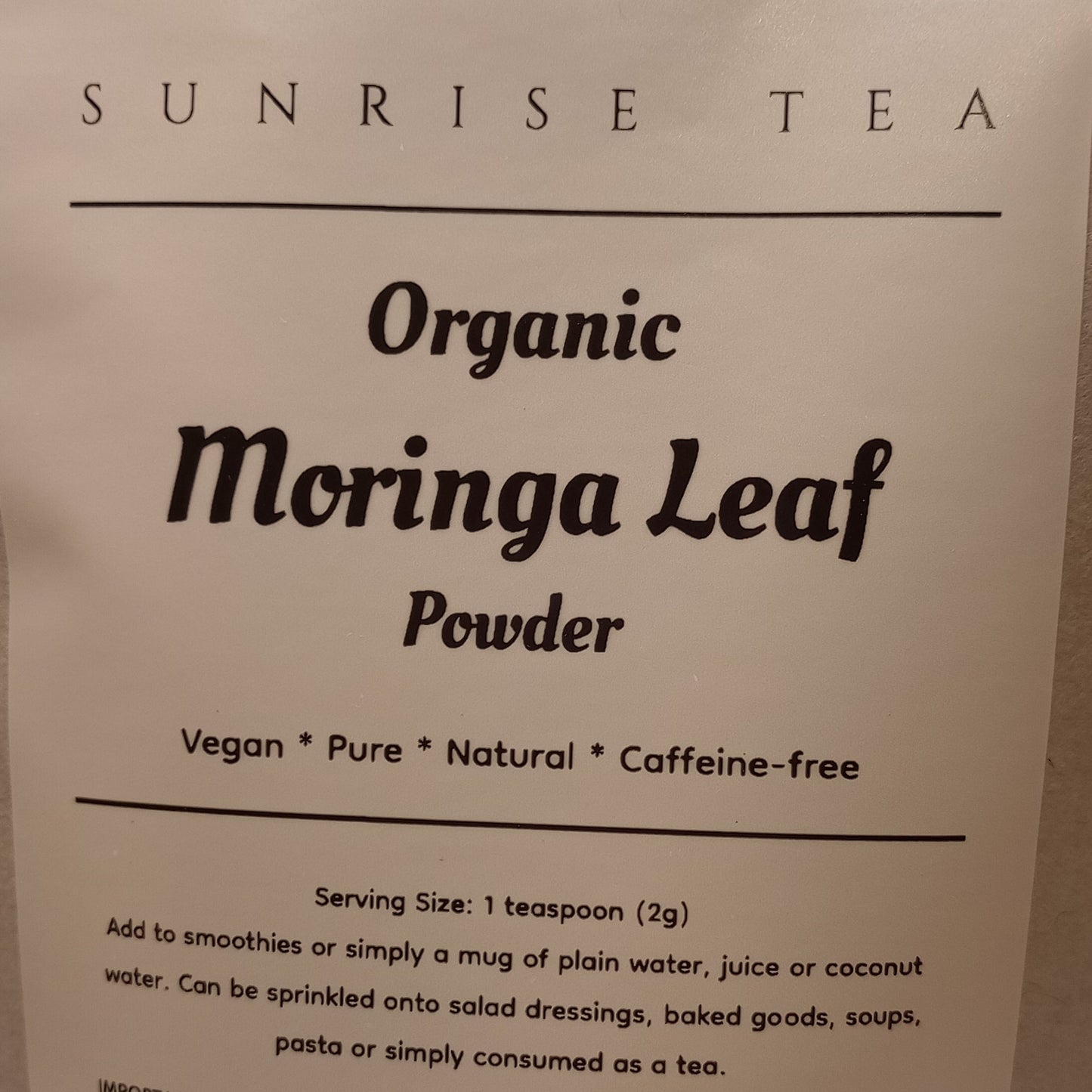 Bag of Organic Moringa Leaf Powder with 'Sunrise Tea' branding on a white background