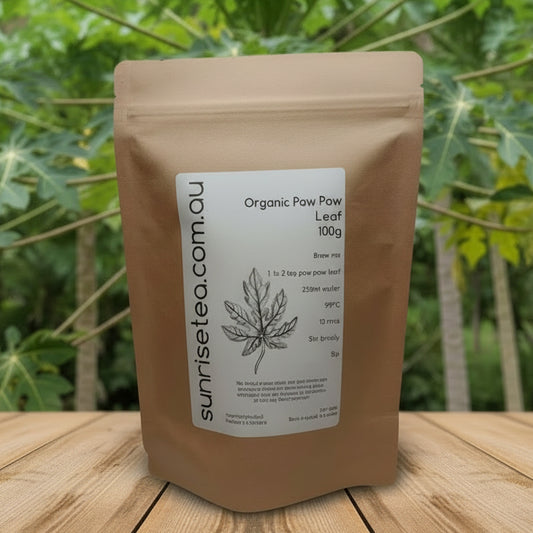 Brown package of Organic Paw Paw Leaf with a label on a wooden surface and green leafy background