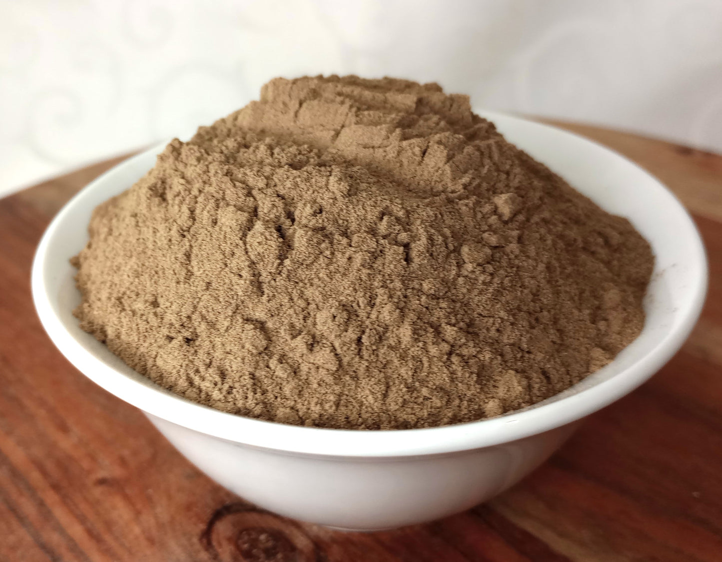 organic black pepper powder in a small white bowl