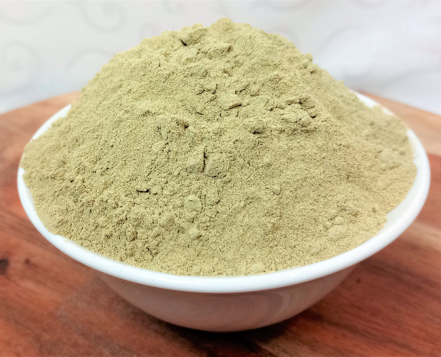 organic broccoli powder in a bowl on a wooden board