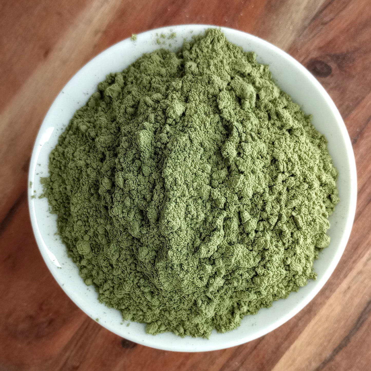 organic dandelion leaf powder in bowl on wooden board