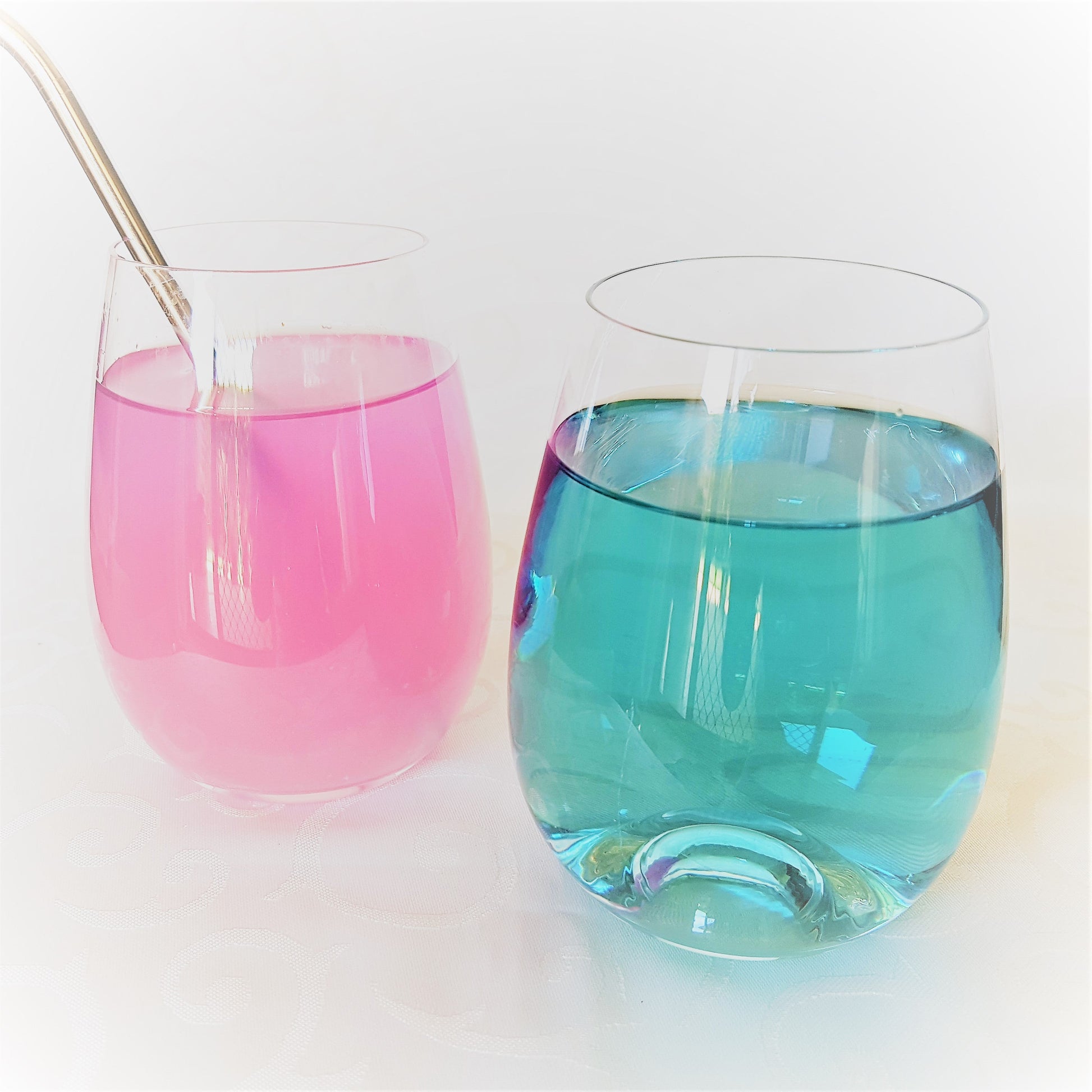 Butterfly pea flower beverages in two glasses. Original colour of tea is blue. Adding a citrus changes it into pink.