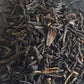 Close up of earl grey tea reveals large black dried strands of black tea leaves accented by orange pieces which could be dried bergamot rind. Earl grey tea can also be flavoured by the oil of the citrus fruit bergamot or its extract.  
