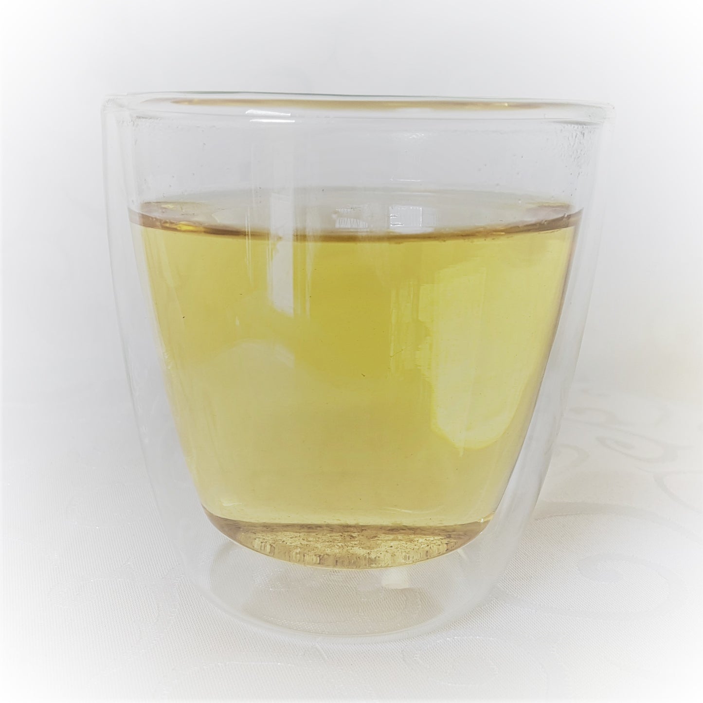 Mullein tea brew in a double walled glass.